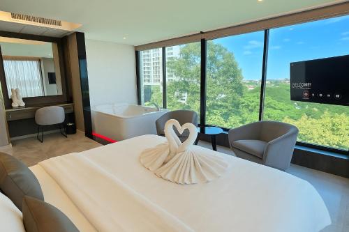 a room with a bed with a heart decoration on it at THE TJ HOTEL Pattaya in Jomtien Beach