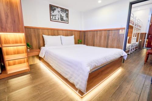 a bedroom with a large white bed in it at Lotus Hotel Đà Lạt in Da Lat