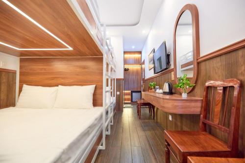 a bedroom with a bed and a desk at Lotus Hotel Đà Lạt in Da Lat