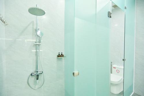 a bathroom with a shower with a glass door at Lotus Hotel Đà Lạt in Da Lat