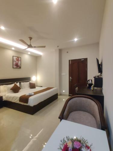 a hotel room with a bed and two chairs at Megha Residency in Ernakulam