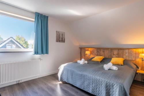 a bedroom with a bed with two stuffed animals on it at Hoogelandt 126 in De Koog