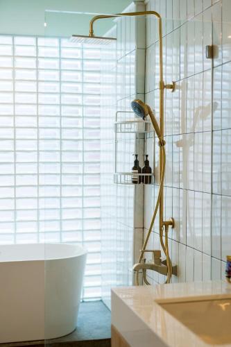 a bathroom with a shower and a tub and a sink at Horizontel in Chiang Rai
