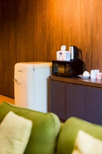 a microwave sitting on a counter next to a refrigerator at Horizontel in Chiang Rai