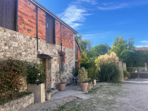 a brick building with potted plants on the side of it at La Fermette Champenoise in Jonquery