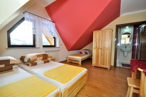 a bedroom with a large bed with a red ceiling at DW Dunajecki Gościniec in Biały Dunajec