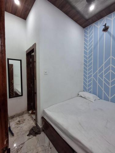 a bedroom with a bed and a blue and white wall at Shri mukut bihari agrawal dharamshala ,dholi pyau himmat pura tiraha mathura in Mathura