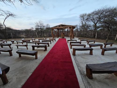 a row of benches with a red carpet and a gazebo at Witgatboom Boskamp in Naboomspruit