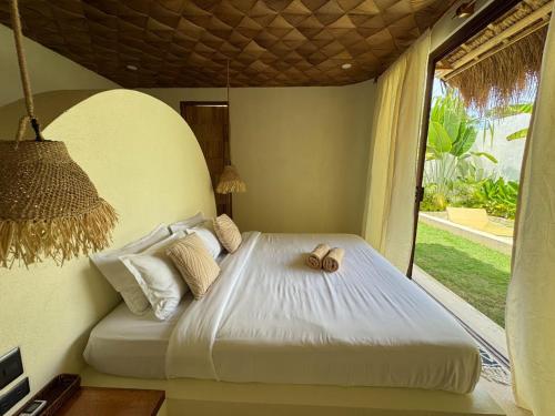 a bedroom with a bed with two towels on it at Baiana Beach Villas in General Luna