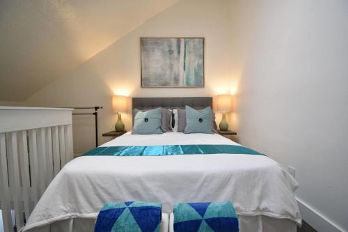 a bedroom with a large bed with blue and green pillows at Loft wqueen loft beach steps in Hollywood