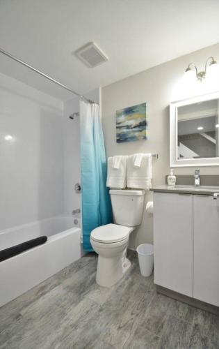 a bathroom with a toilet and a tub and a sink at Loft wqueen loft beach steps in Hollywood