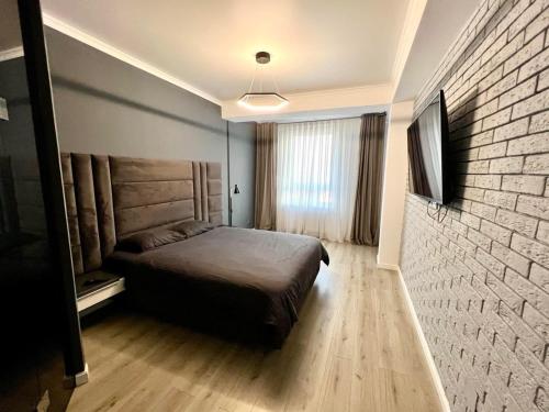 a bedroom with a bed and a brick wall at Oasis Residence Luxury Apartament in Chişinău