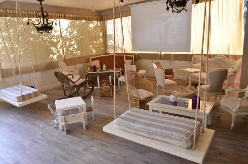 a room with chairs and tables and a swing at EcoHotel Ristorante Milano in Borgo a Mozzano