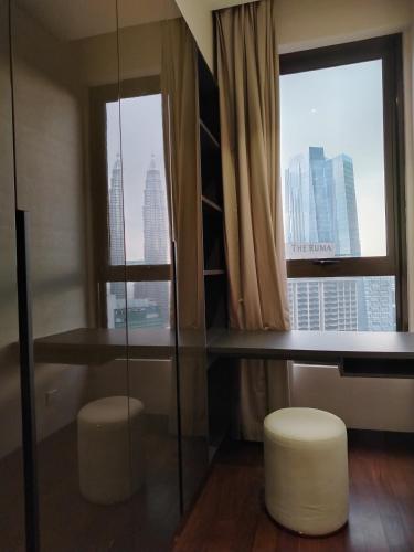 a room with two windows and a table and two stools at KL suites by Nomad in Kuala Lumpur