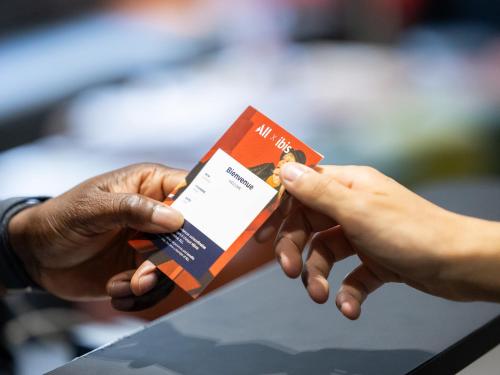 two people holding up a credit card in their hands at ibis Paris Alesia Montparnasse in Paris