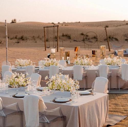 a group of tables with white chairs and flowers at The Desert Resort Jaisalmer in Jaisalmer