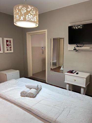 a bedroom with a bed with two towels on it at Hotel Domo in Prudentópolis