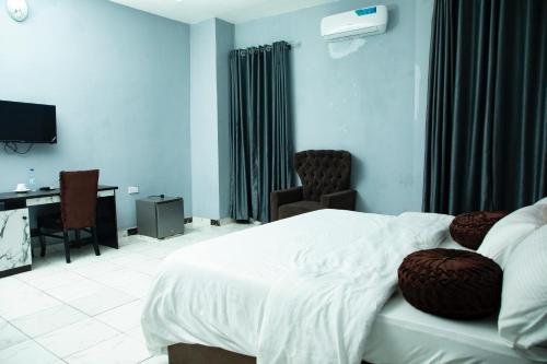 a bedroom with a bed and a desk and a television at Portview hotel in Mama