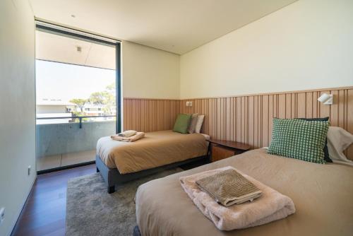 ein Hotelzimmer mit zwei Betten und einem Fenster in der Unterkunft Cascais Sandwoods Luxury Villa in Cascais