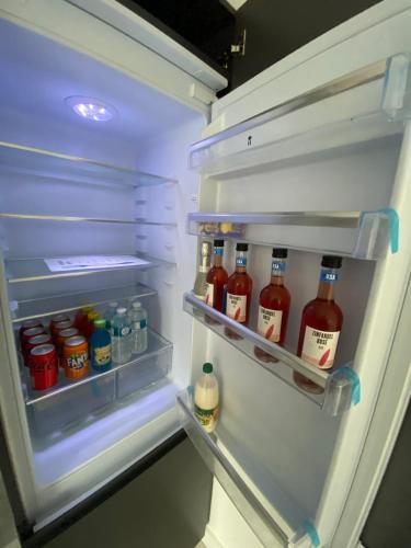 a refrigerator filled with lots of bottles of sauce at Modern Luxury Escape Suite In The Heart of Urmston Town Centre in Urmston