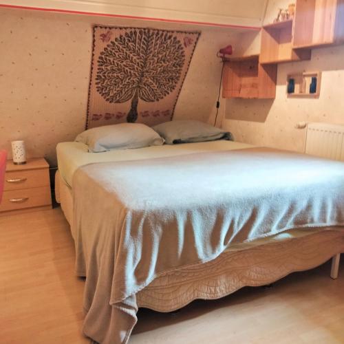 a bedroom with a bed with a tree on the wall at Petit nied Cosy au Calme in Obernai