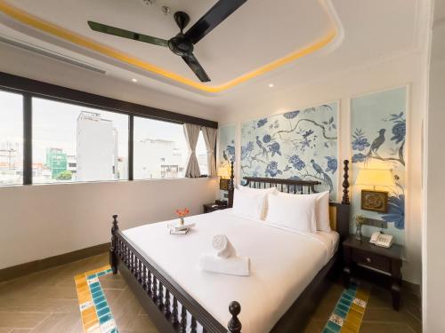 una camera con un grande letto e un ventilatore a soffitto di Natalie Boutique Hotel Da Nang a Da Nang