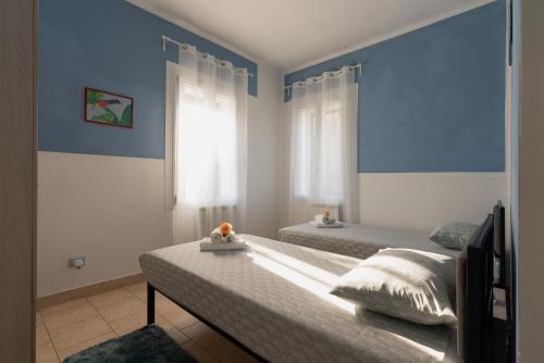 Un dormitorio con dos camas con paredes azules y una ventana. en GajoSanti apartments, en Vicenza