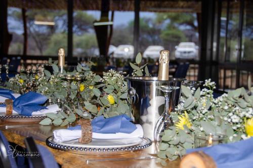 a table with flowers and napkins on top at Witgatboom Boskamp in Naboomspruit