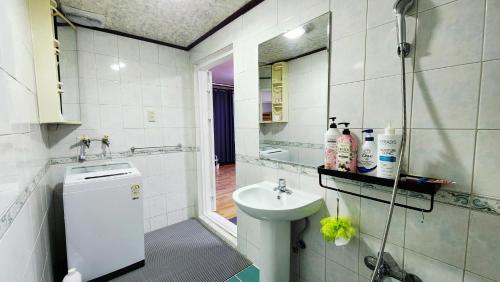 a white bathroom with a sink and a toilet at 반월당 스테이션 #1 in Daegu