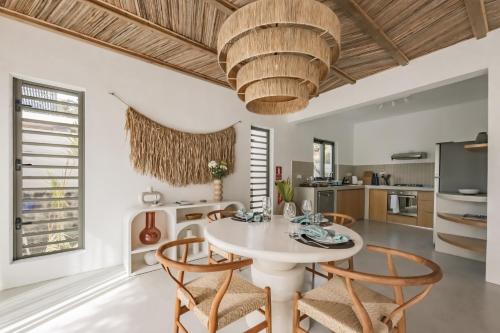 a dining room with a white table and chairs at Searenity Villas in Rivière Noire