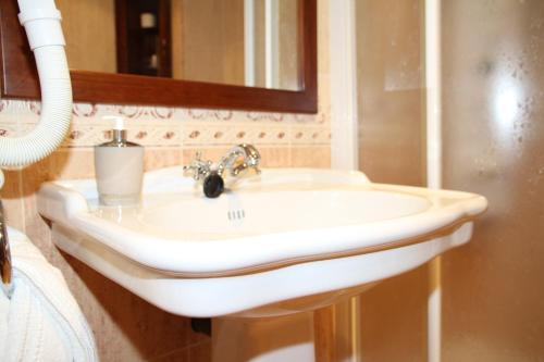 a white sink in a bathroom with a mirror at Posada Casa de don Guzman in Vega de Pas