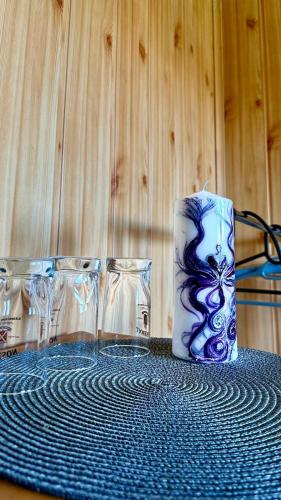 a table with three glasses and a candle on it at Penzion Pod Lípou in Dolní Brusnice