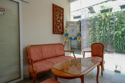 a living room with a couch and a glass table at RedDoorz @ Jalan Majapahit Semarang in Alastuwo