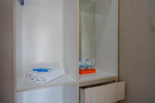 a cabinet with towels and a mirror in a bathroom at RedDoorz @ Jalan Majapahit Semarang in Alastuwo