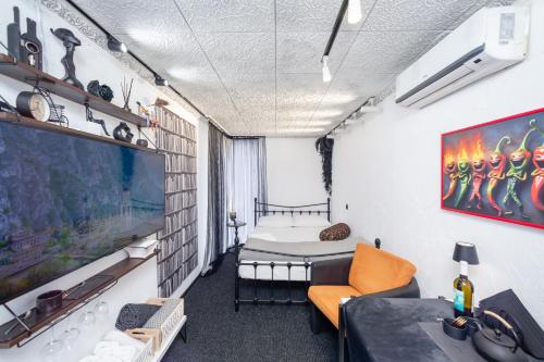 a room with a bed and a couch and a tv at Bude in Mtskheta