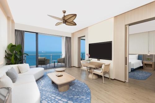 a living room with a white couch and a tv at C&D Hotel Dongshan Zhangzhou in Tongling