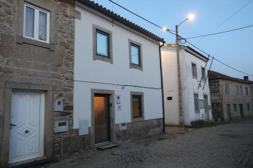 a white building with a door on a street at Cantinho do Sossego in Miranda do Douro