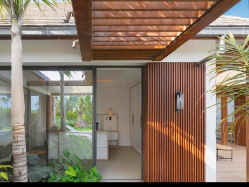 an open door to a house with a palm tree at Villa Laeti in Saint-Jean