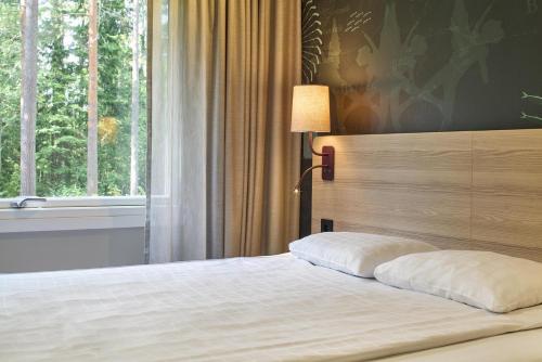 a bedroom with a bed with a large window at Scandic Gävle Väst in Gävle