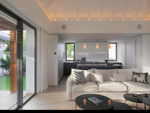 a living room with a white couch and a kitchen at Villa Laeti in Saint-Jean