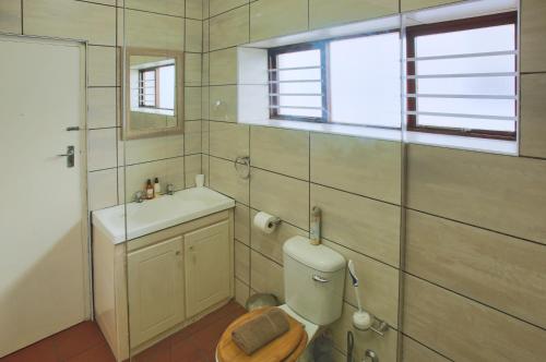 een badkamer met toilet, wastafel en raam bij Sea Cottage, Langebaan, 4-sleeper in Langebaan