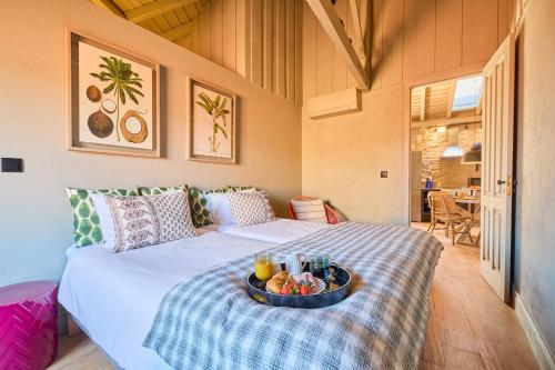 Zimmer mit einem Bett und einem Tablett mit Obst darauf in der Unterkunft Melro Cottage House, Douro Valley in Aldeia de Baixo