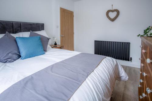 a bedroom with a large bed with a blue pillow at Wiston Street - 2 Bedroom Holiday Home - Pembroke in Pembroke