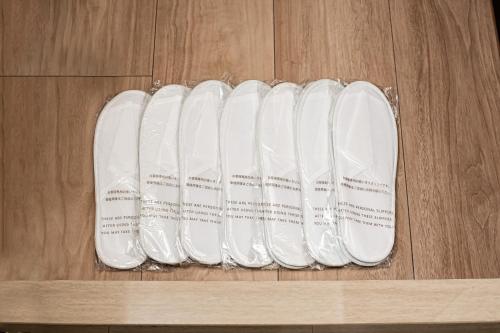 a group of white shoes sitting on a wooden floor at ルーベンス博多 in Fukuoka
