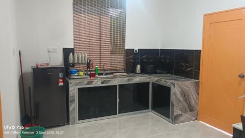 a kitchen with a sink and a refrigerator at Anatolia Cottage in Wakaf Baharu