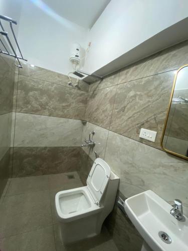 a bathroom with a toilet and a sink at DOWN TOWN HOLIDAYS Kovalam in Kovalam