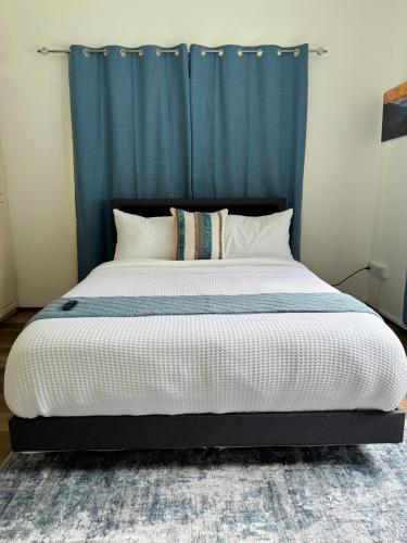 a bedroom with a large bed with a blue curtain at Diamond Pines in Kingstown