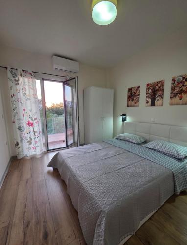 a bedroom with a large bed and a large window at Kos central vibes - Casa Vasilis in Kos