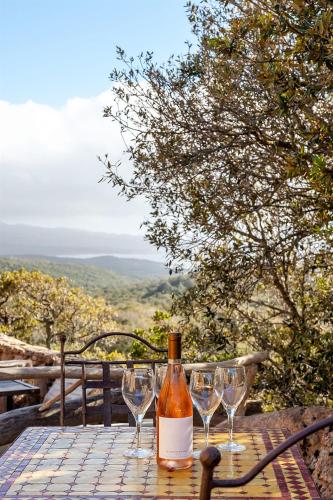 a bottle of wine sitting on a table with wine glasses at LAlpana in Figari