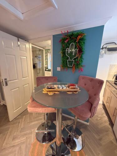 a table in a kitchen with two chairs and a mirror at Thorpe Park Studio - Detached Stay & Free Gated Parking in Thorpe